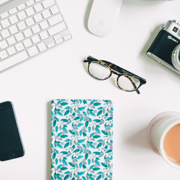 A desk with notebook and glasses on