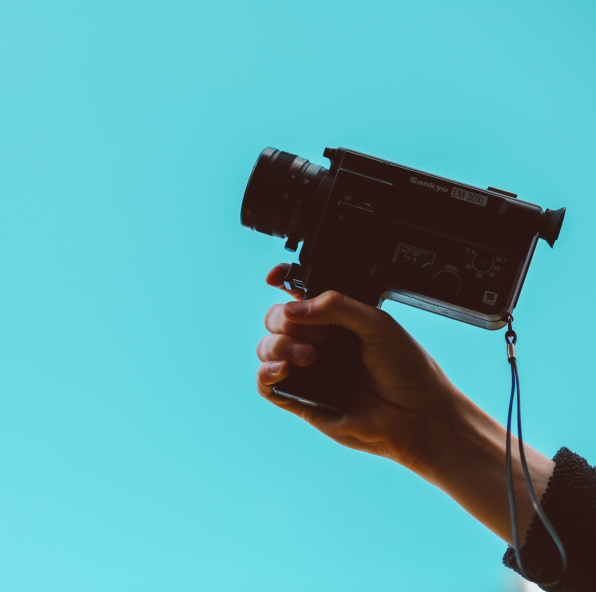 A hand holds camera on blue background